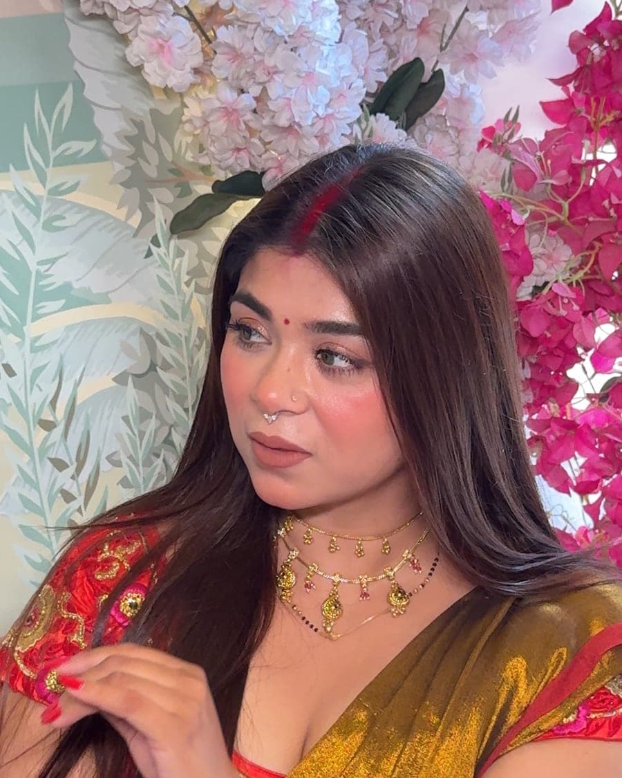 Bride with long dark hair, traditional jewellery and a red and gold outfit